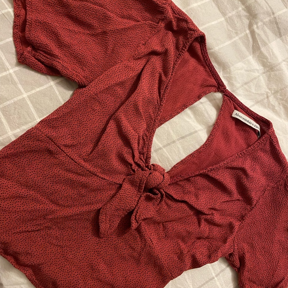 Short sleeve maroon with black polka dots shirt.